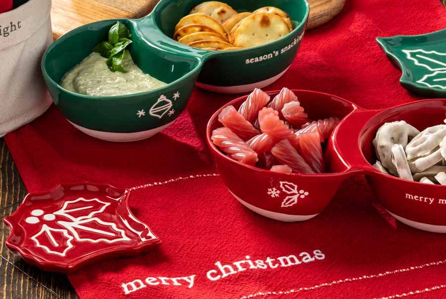 Christmas table runner with bowls of snacks on top.