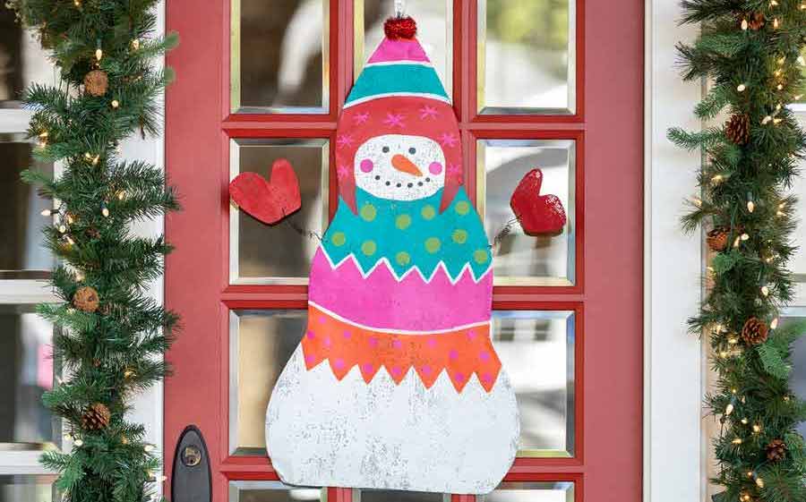 Snowman door hanger on a red front door.